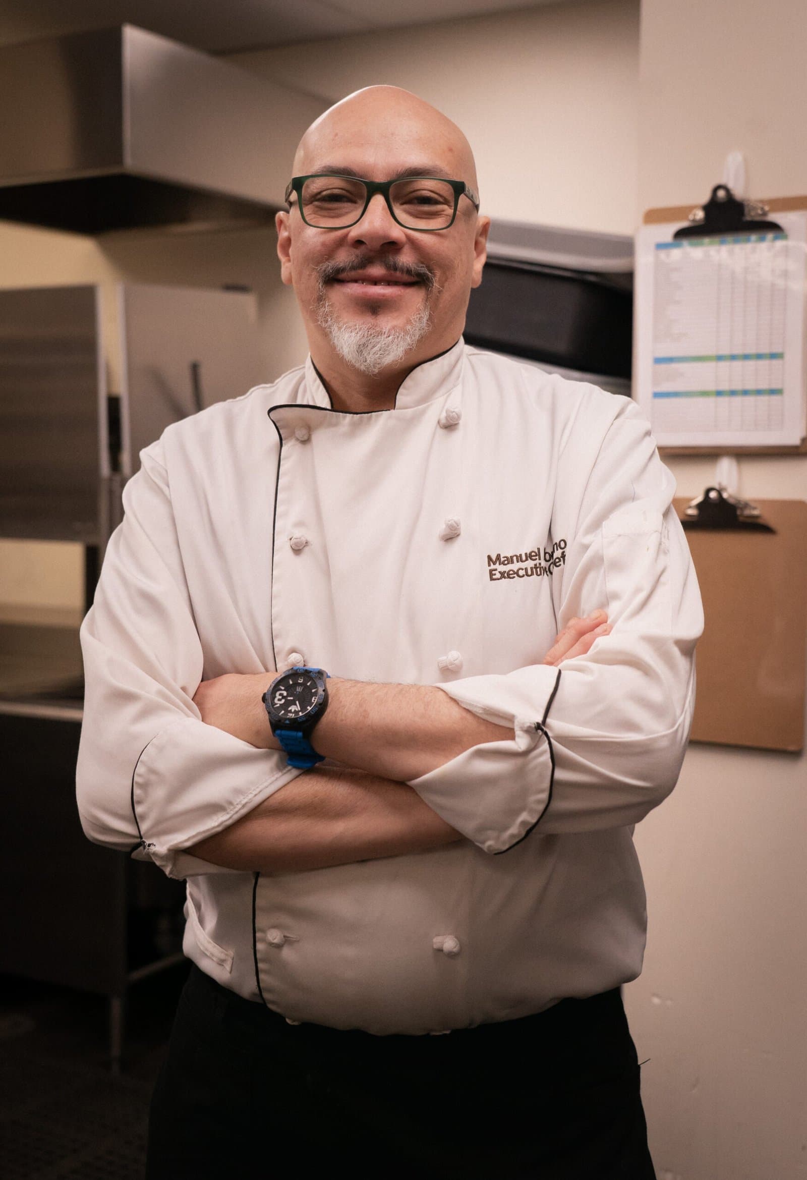 Chef Manuel Moreno, founder of Tak-Oh, arms folded in his kitchen whites